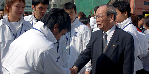 乗船時、１人ひとりと握手を交わす松前理事長・総長